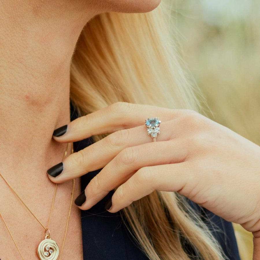 girl wearing a london blue topaz cocktail ring and a celtic swirl necklace.