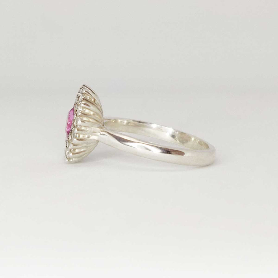 Pink and white sapphire cluster ring in argentium silver from side on white background