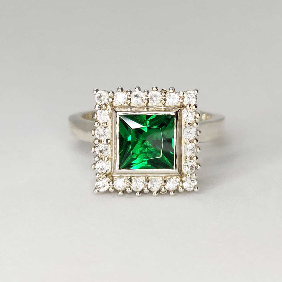 Princess cut emerald with white sapphire cluster in argentium silver on white background