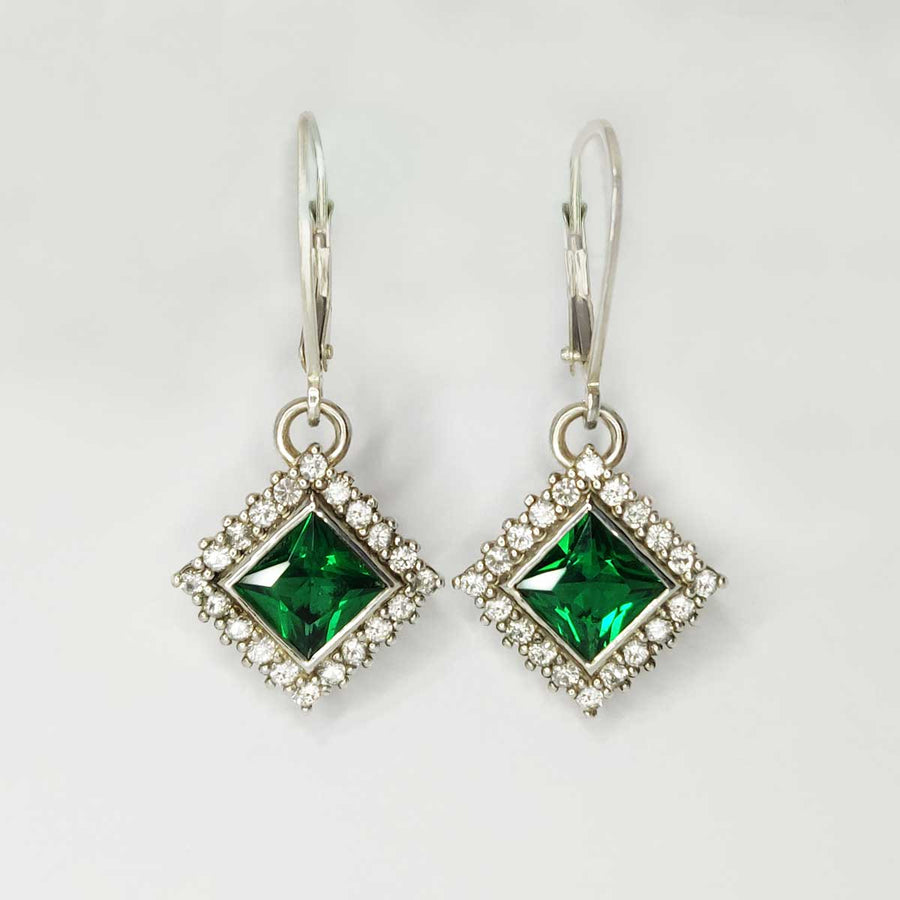 Princess cut emerald and white sapphire cluster earrings in argentium silver on white background