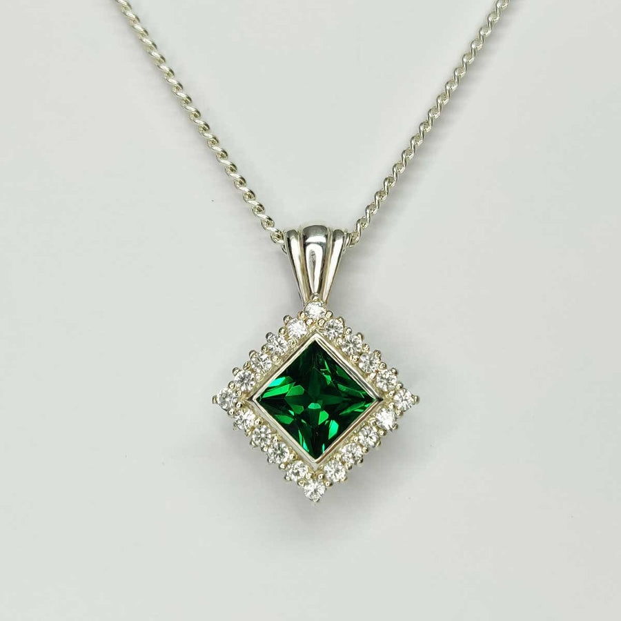 Princess cut emerald and white sapphire cluster necklace in argentium silver on white background